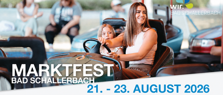 A smiling woman and a young girl are riding a bumper car at an amusement park. The woman is holding the steering wheel, and the girl is sitting beside her. The image has a watermark with the text 'TXTFEST KELLERBACH 21. - 23. AUGUST'.
