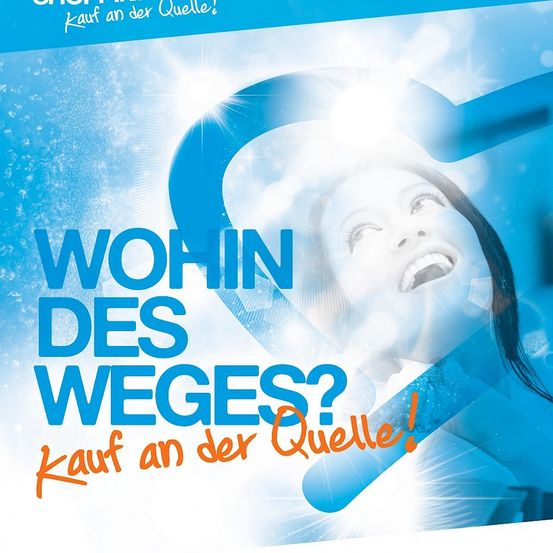 Ein Poster zeigt eine lächelnde Frau mit dem Text 'Wohin des Weges?' über ihrem Kopf. Darunter steht in fetter Schrift 'Kauf an der Quelle!'