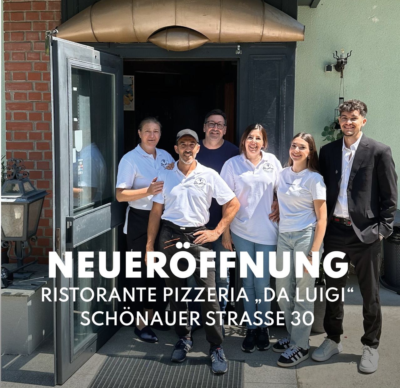 Eine Gruppe von Menschen steht vor einem Restaurant mit offener Tür. Sie lächeln und posieren für ein Foto. Das Schild sagt 'Neueröffnung Ristorante Pizzeria Da Luigi Schonauer Strasse 30'.