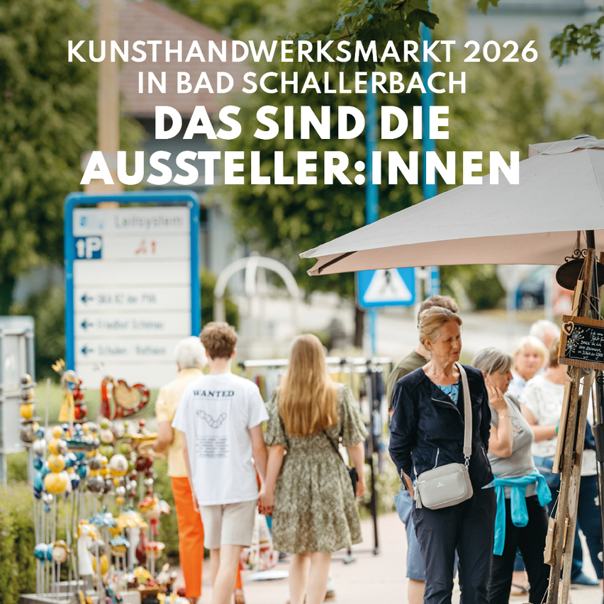 Menschen schlendern an Kunst- und Handwerksständen auf dem Kunsthandwerksmarkt 2026 in Bad Schallerbach, Österreich. Begleitet werden sie von einer Frau mit einer Tasche unter einem Schirm.