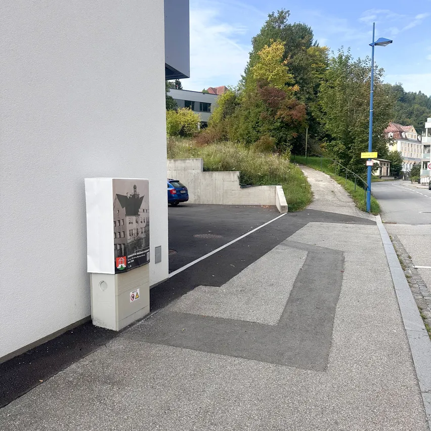 Ein Parkplatz mit einer weißen Box am Straßenrand.