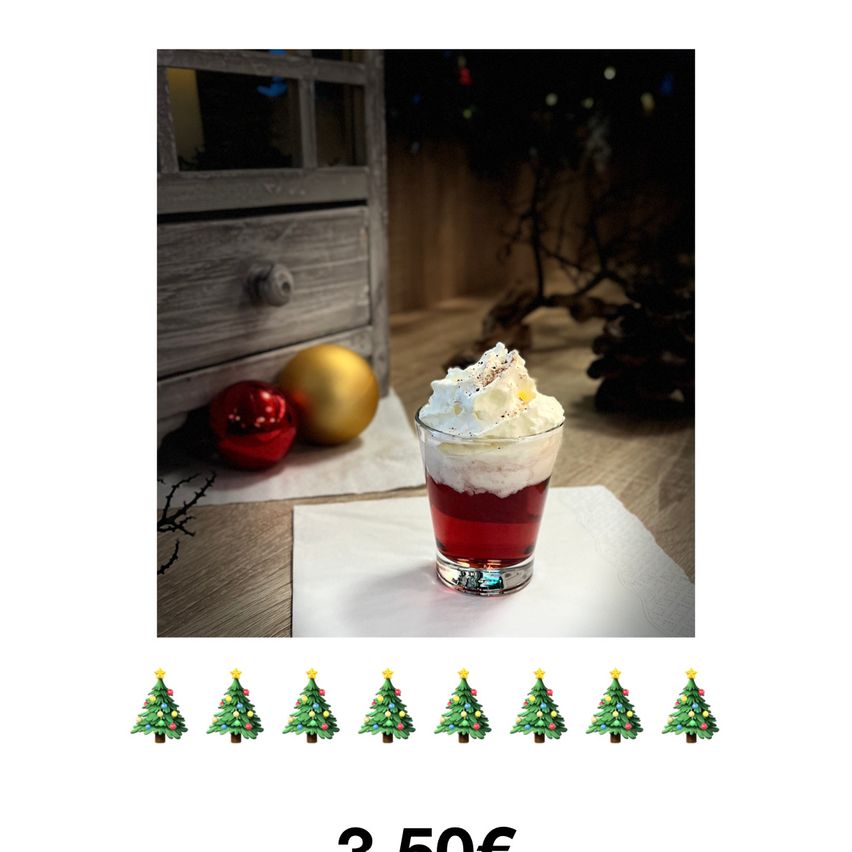 Ein festlicher Cocktail-Glas mit Schlagsahne, roter Flüssigkeit und Weihnachtskugeln. Der Preis beträgt 350€.