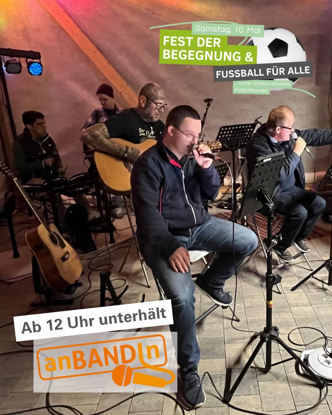 Eine Gruppe von Menschen tritt auf der Bühne auf. Ein Mann vor ihm singt in ein Mikrofon. Dahinter spielen zwei Männer Gitarre. Ein anderer Mann sitzt auf einem Stuhl und spielt Schlagzeug. Die Bühne hat einen gefliesten Boden und ein Banner mit den Worten 'Fußball für alle'.