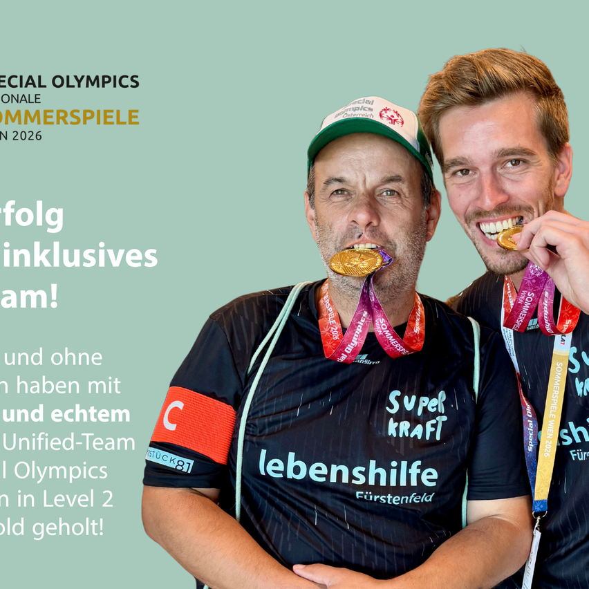 Zwei Männer mit Goldmedaillen feiern bei den Special Olympics 2026. Sie tragen das gleiche Uniform, beschriftet mit Lebenshilfe.