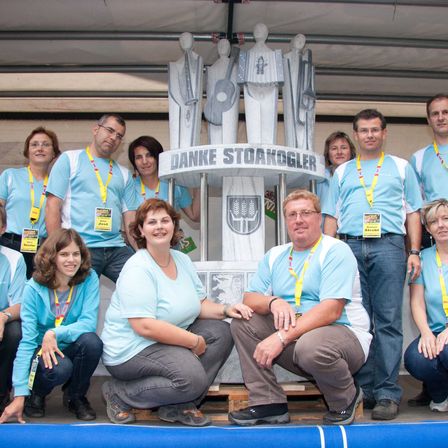 Bild enthält, People, Person, Shoe, Pants, Wristwatch, Groupshot, Adult, Male, Man, Glasses