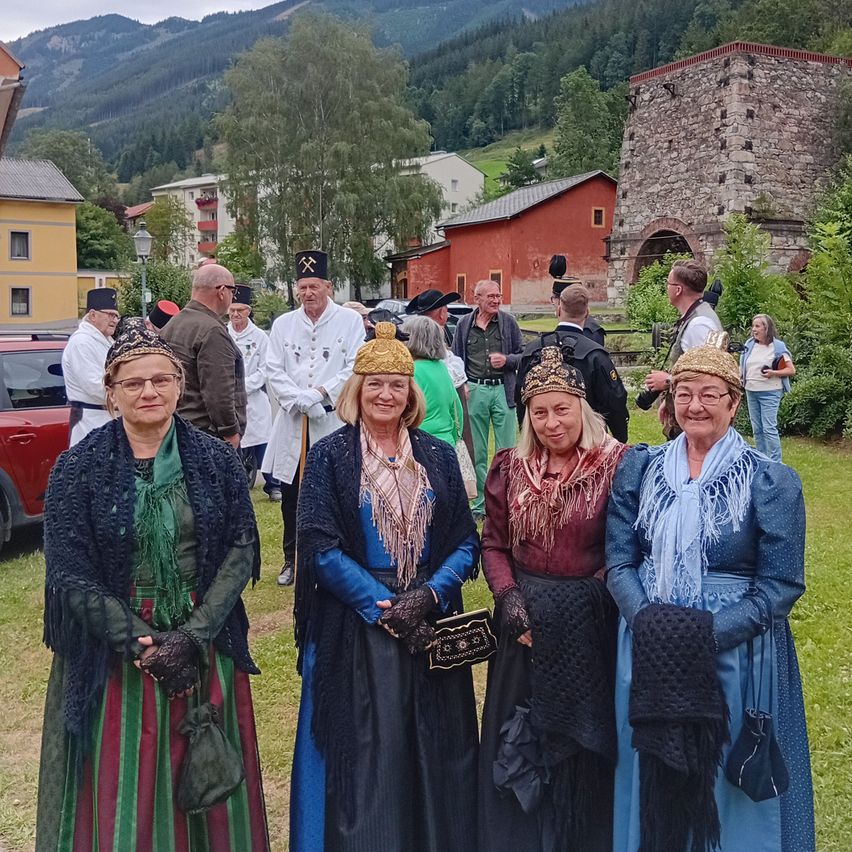 Frauen in Tracht mit Bergmannsmännern vor historischem Gebäude in Eisenerz