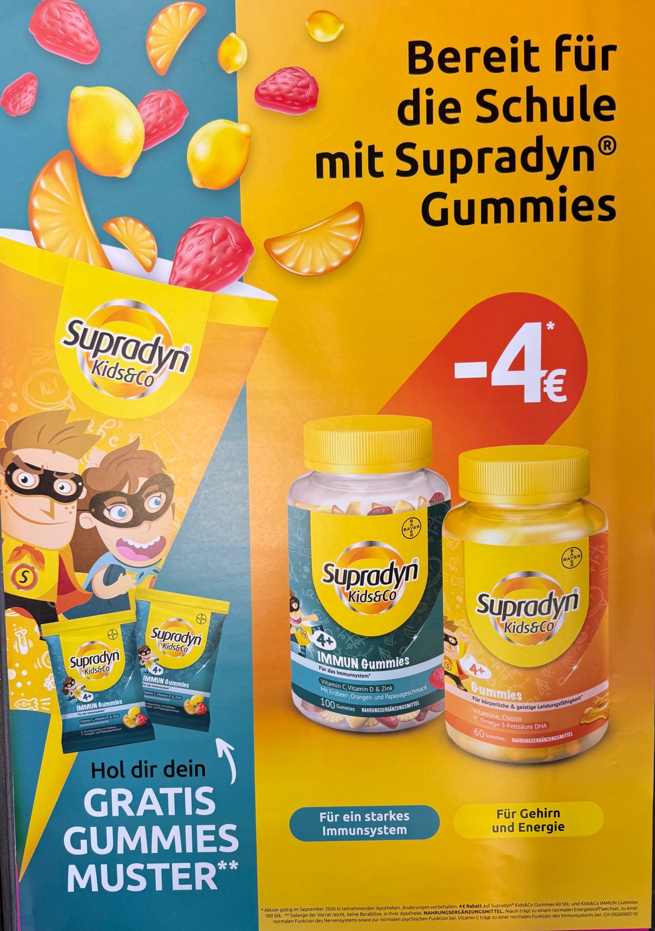 Eine Werbung für Supradyn Kids & Co Vitamine zeigt zwei Flaschen mit Gummibärchen, eine mit der Aufschrift 'IMMUNITY GUMMIES' und die andere 'GUMMIES'. Die Werbung zeigt Cartoon-Charaktere und einen Preis von -4 Euro.