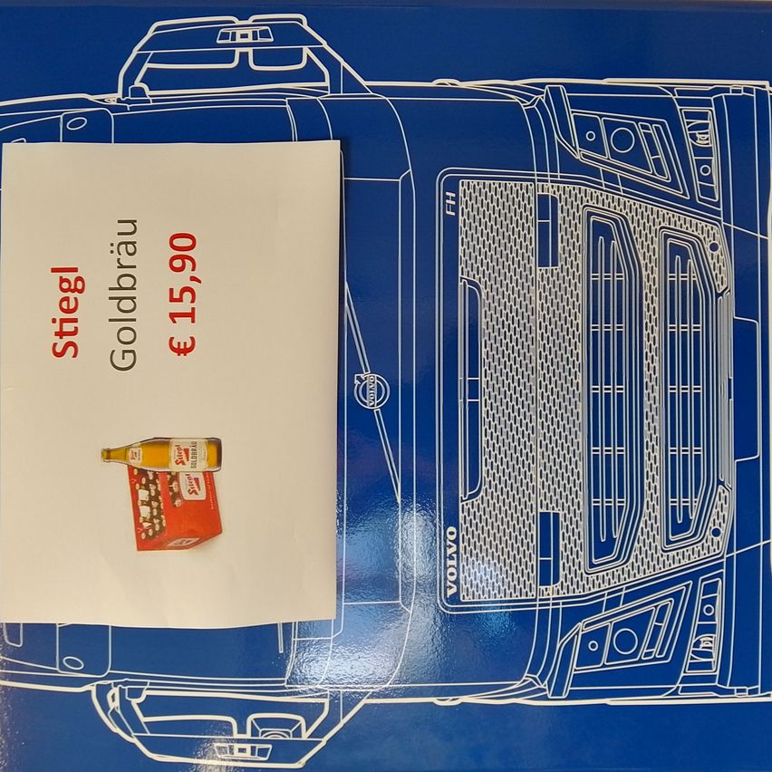 Eine Werbung zeigt eine blaue Umrisse eines LKWs mit dem Wort 'Stiegl' in Rot und einem Preis von 15,90 Euro. Links ist eine Illustration einer Bierflasche und eines Kartons zu sehen.