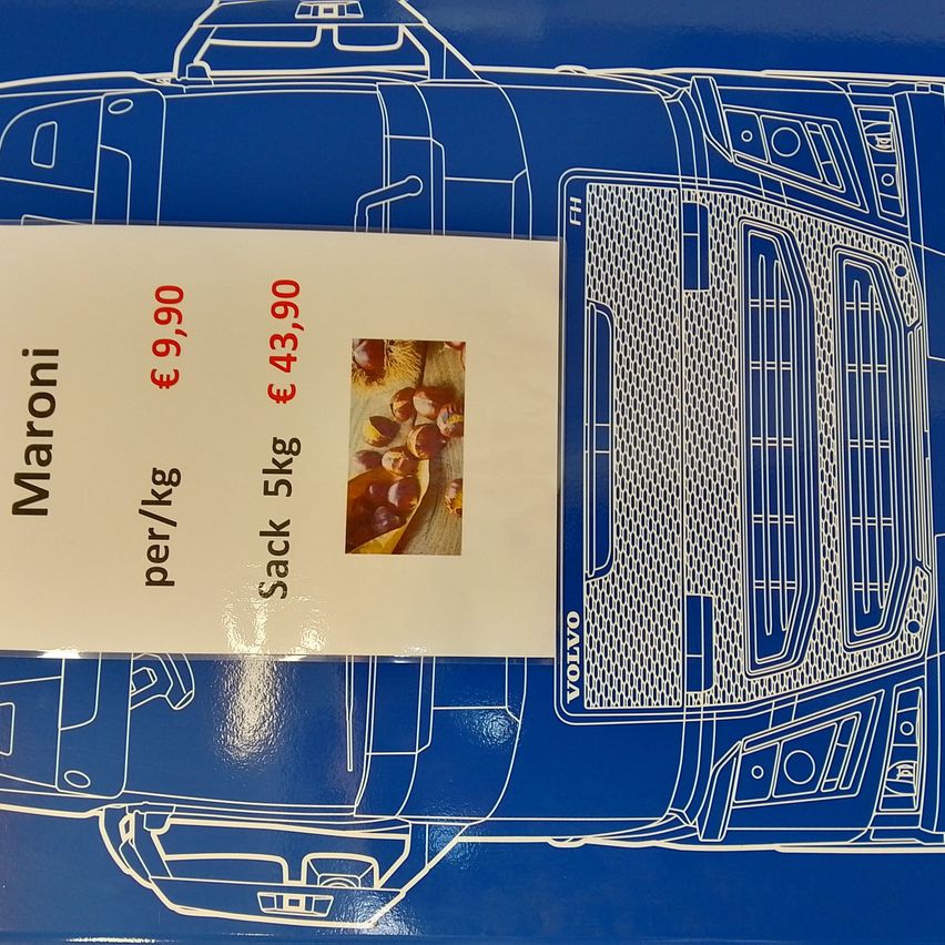 Ein blauer Hintergrund zeigt ein weißes Etikett mit einer Grafik eines Lastwagens mit der Aufschrift 'Volvo'. Das Etikett enthält einen Preis von 43,90 € für einen 5 kg Sack und 9,90 € pro Kilogramm. Ein Bild von Kastanien ist ebenfalls vorhanden.