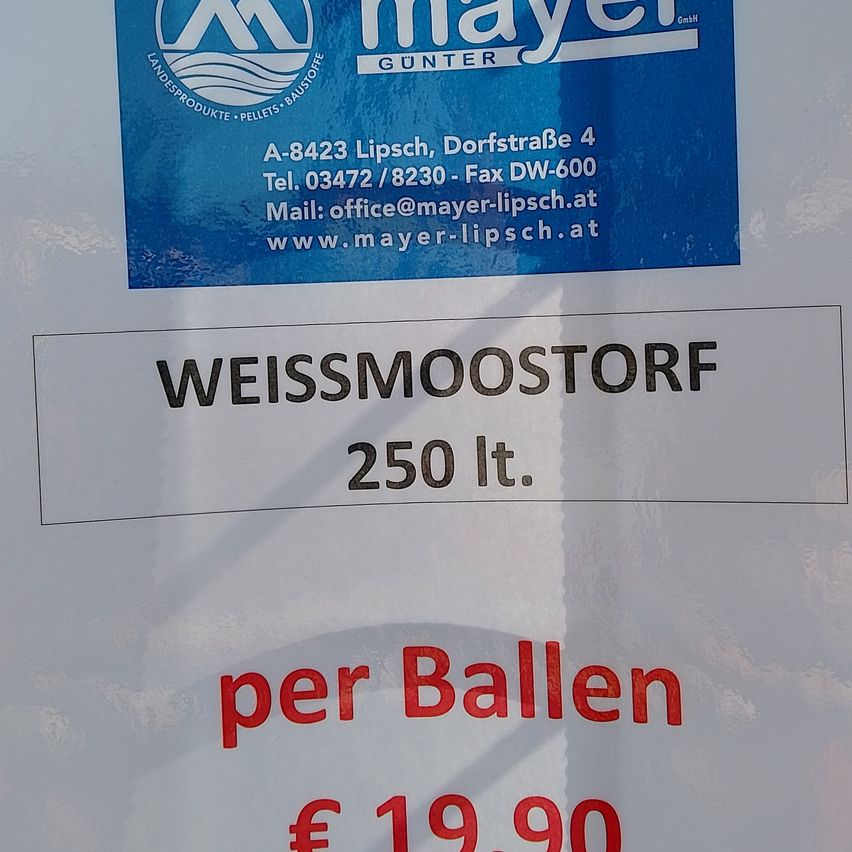 Ein blaues Schild von Mayer Gunter zeigt Kontaktdaten und Produktdetails. Darunter steht auf einem weißen Etikett Weissmoostorf, 250 Liter, pro Ball und kostet 19,90 €.