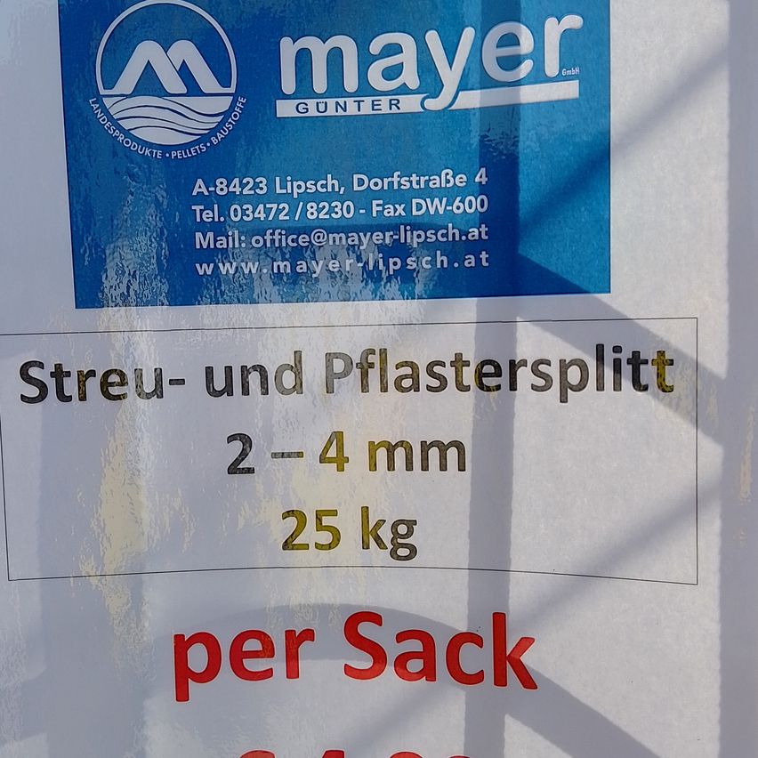 Ein blaues Etikett zeigt die Adresse und Kontaktdaten von Mayer Gunter. Darunter steht 'Streu- und Pflastersplitt 2-4mm 25kg pro Sack'.