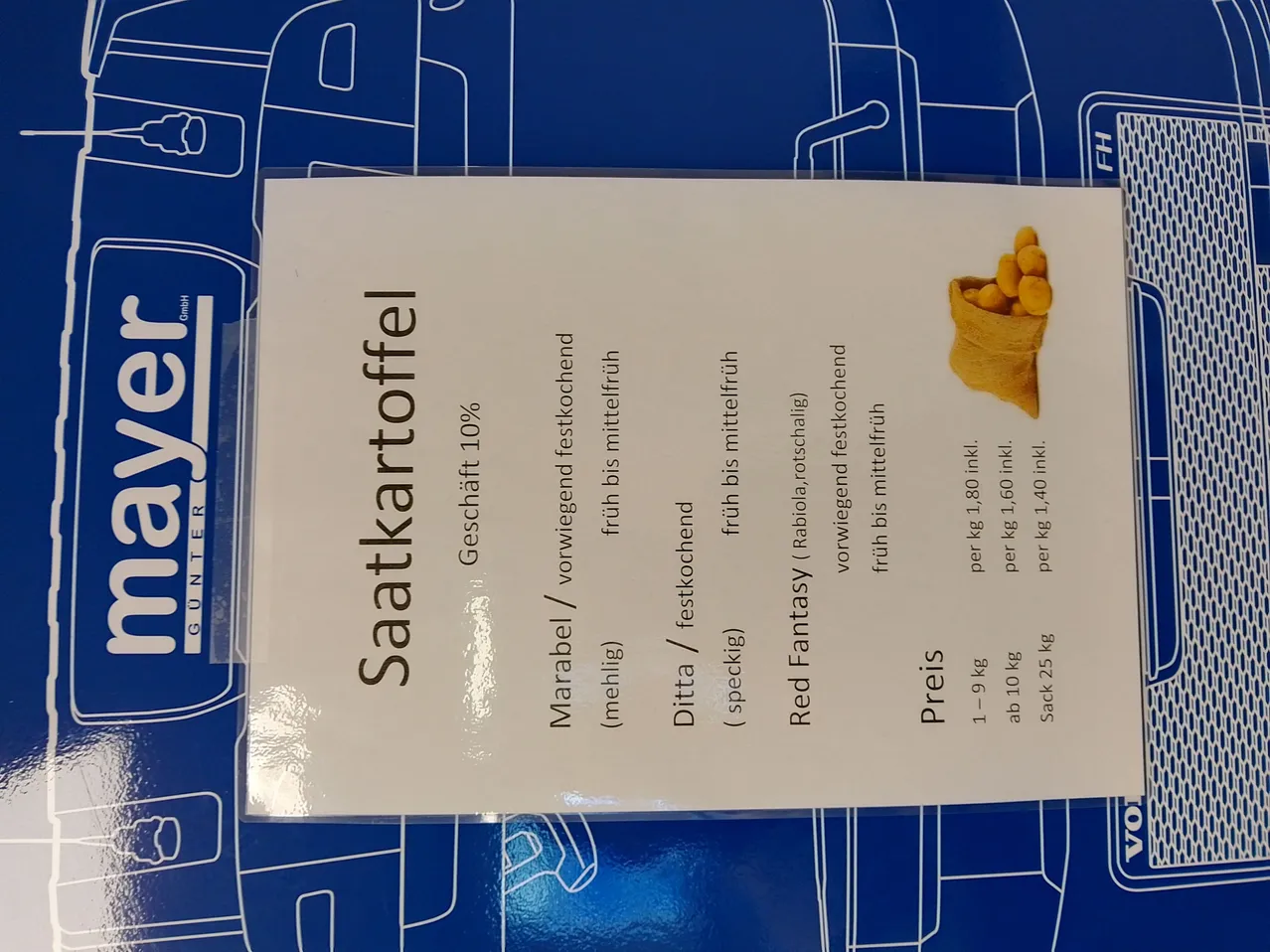 Eine blaue Verpackung enthält einen Beutel mit Samen. Es listet zwei Arten von Samen auf: Marabelle und Ditta. Die Preise sind pro 1-9 kg, 10-25 kg und einem Beutel von 25 kg. Die Preise reichen von 10,80 bis 40,10.