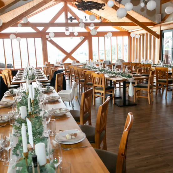 Ein großer Innenbereich mit Holzmöbeln, langen Tischen und einer Vielzahl von Gerichten und Dekorationen.