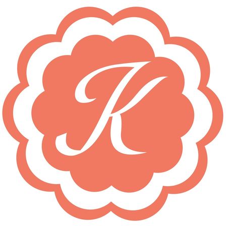 Ein stilisierter weißer Buchstabe 'K' in einem pfirsichfarbenen kreisförmigen Design mit weißen Blütenblättern.