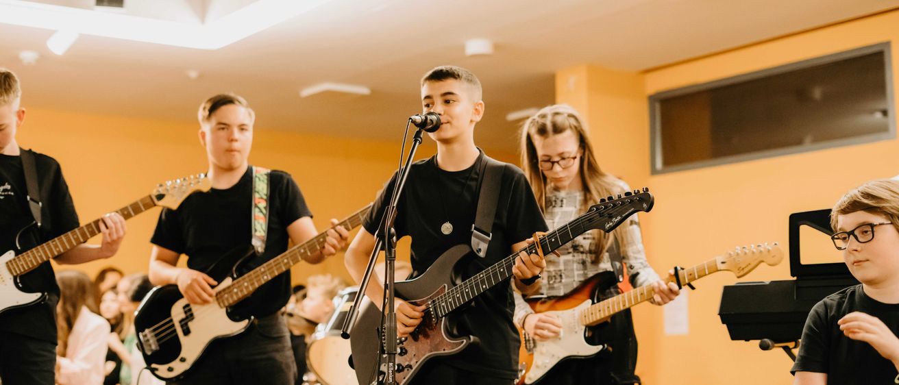 Bild enthält, Adult, Male, Man, Person, Guitar, Microphone, Female, Woman, Boy, Teen