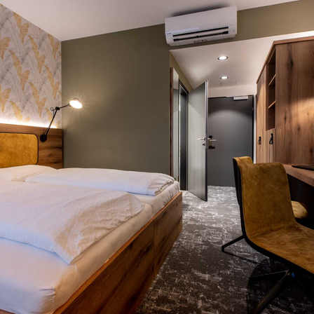 Bild enthält, Indoors, Interior Design, Home Decor, Bedroom, Dorm Room, Furniture, Wood, Laptop, Cushion, Monitor