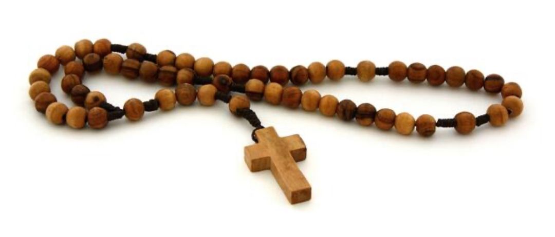 Eine Rosenkranz aus Holzperlen mit einem hölzernen Kreuz wird auf einem weißen Hintergrund gezeigt.