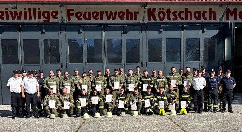 Eine Gruppe von Feuerwehrleuten in grünen Uniformen posiert für ein Foto vor der Feuerwehrstation Kotschach.