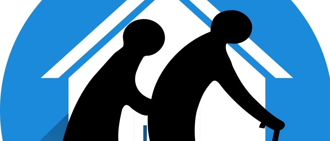 Silhouette von zwei älteren Menschen, die mit einem Stock und Hand in Hand vor einem Haus gehen.