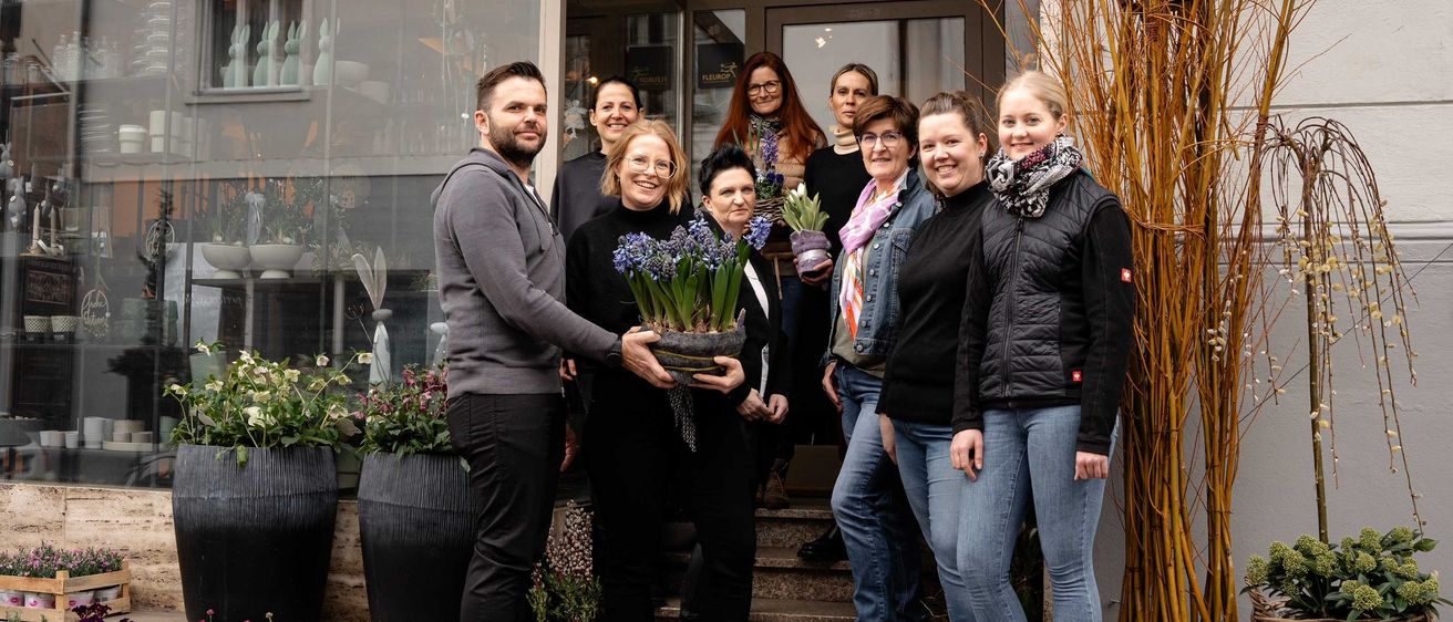 Bild enthält, Potted Plant, Groupshot, Person, People, Pants, Adult, Male, Man, Planter, Scarf