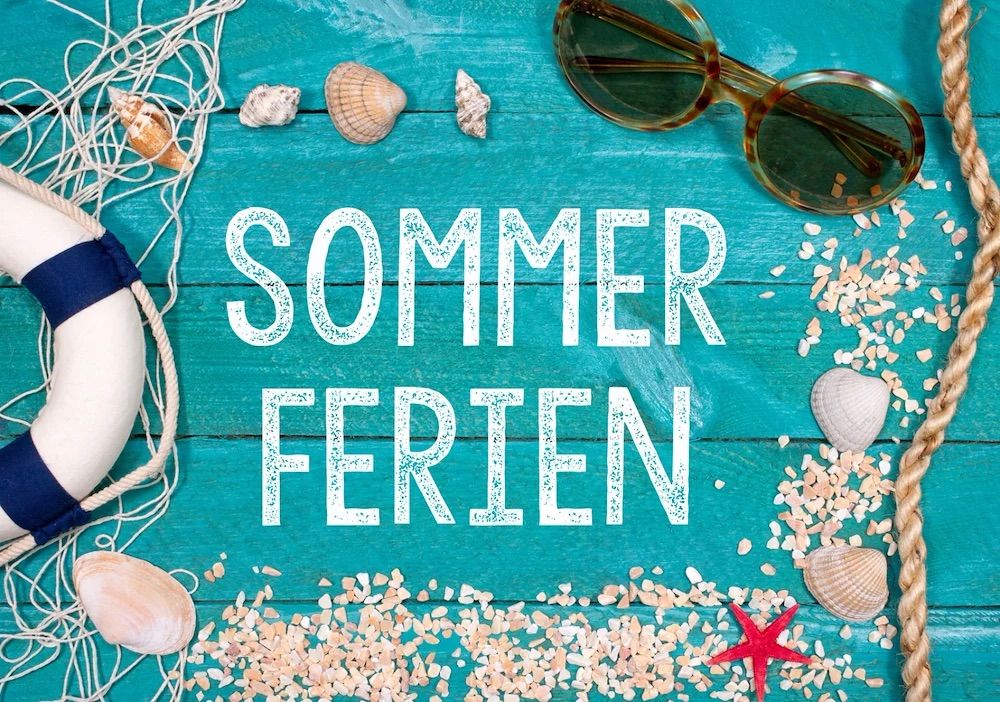 A blue wooden background with the words 'Sommer Ferien' written in white. Surrounding the text are various seashells, a starfish, and sunglasses. The seashells are arranged in a way that resembles a decorative pattern.