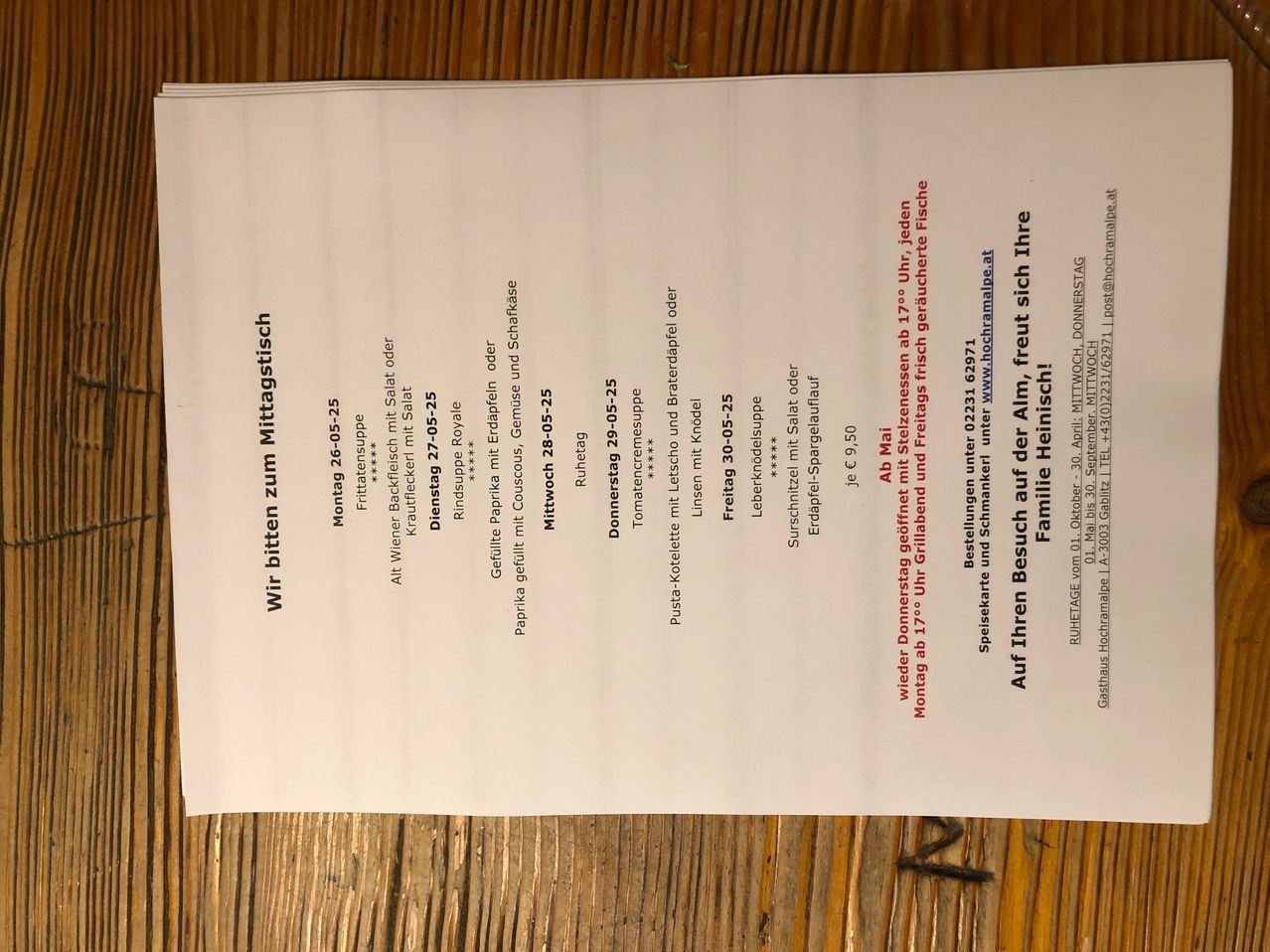 Das Bild zeigt eine Speisekarte mit verschiedenen Gerichten und deren Preisen. Die Gerichte sind mit ihren Namen, Zutaten und Preisen in Euro aufgeführt. Die Karte enthält auch ein spezielles Angebot für eine Familie von drei Personen.