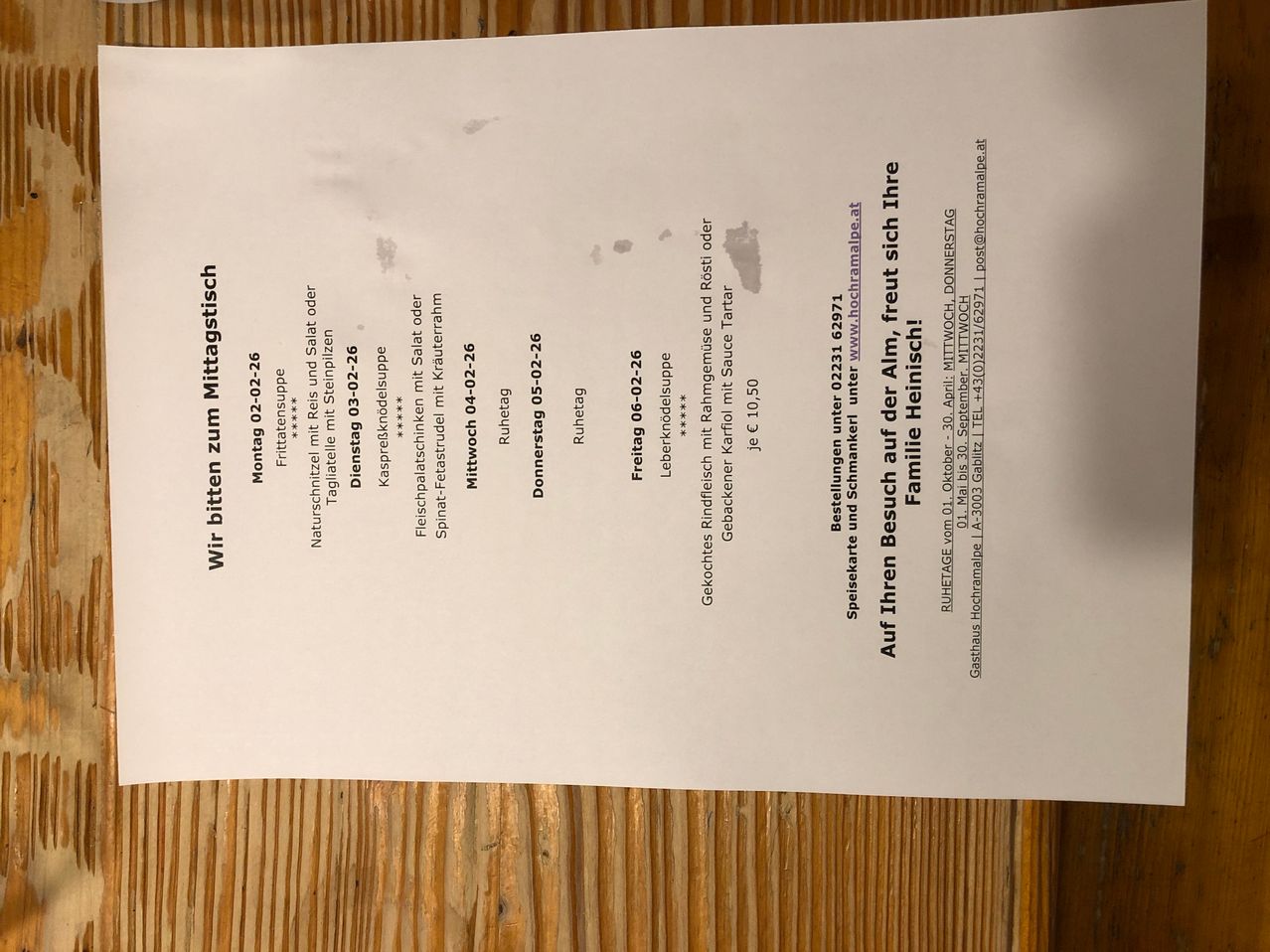 Ein Dokument mit einer Auflistung verschiedener Fleischgerichte und deren Preisen, wahrscheinlich eine Speisekarte eines Restaurants. Gerichte umfassen Steaks, Würste und Schweineschenkel, mit Preisen von 10,50 bis 22,90 Euro. Das Dokument enthält eine E-Mail-Adresse für Anfragen und erwähnt eine familienfreundliche Atmosphäre.