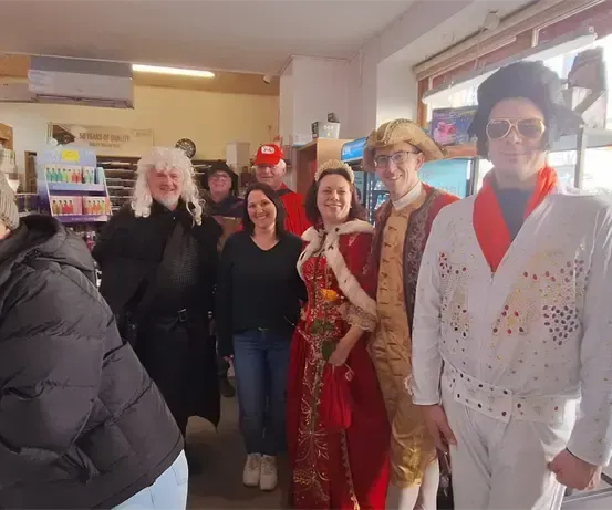 Eine Gruppe von Menschen in verschiedenen Kostümen posiert für ein Foto in einem Geschäft.