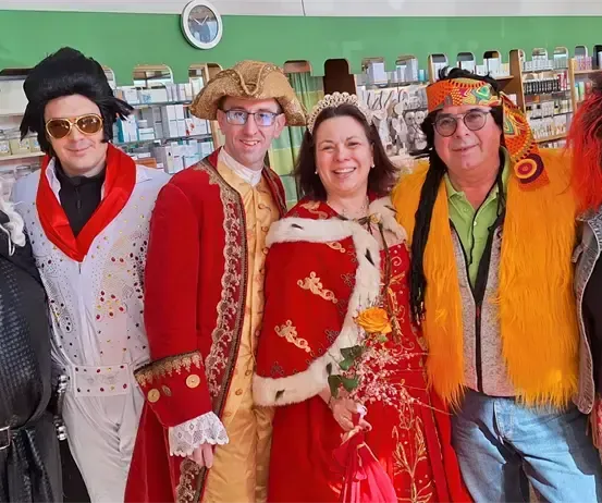 Eine Gruppe von Menschen in verschiedenen Kostümen posiert für ein Foto in einem Geschäft.