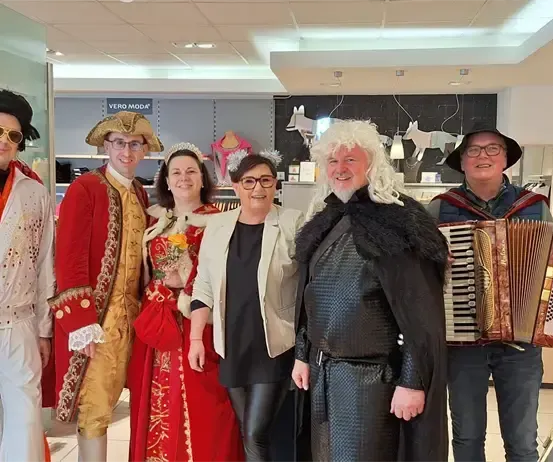 Eine Gruppe von Menschen in Kostümen posiert für ein Foto in einem Geschäft.