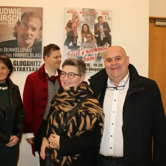 Fünf Personen posieren für ein Foto vor einem Plakat für das Theaterstück Spiel's nochmal Sam.