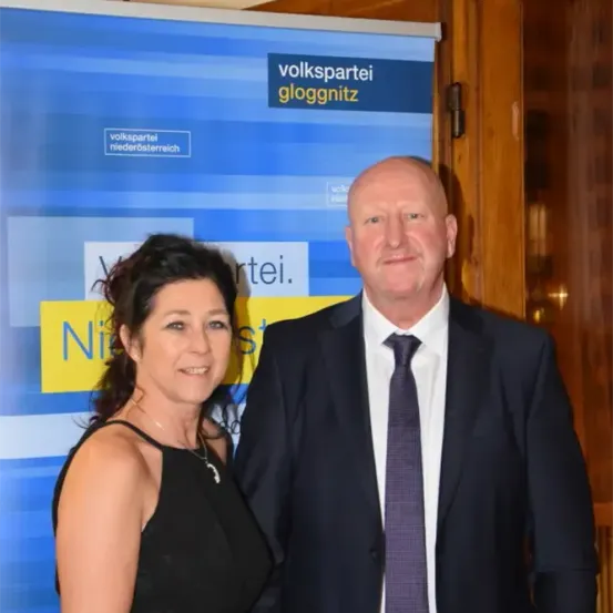 Ein Mann und eine Frau stehen nebeneinander vor einem blau-gelben Banner, auf dem 'Volkspartei Niederösterreich' steht.
