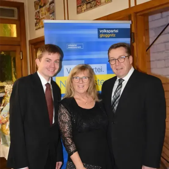 Drei Personen stehen nebeneinander vor einem Banner der Volkspartei Niederosterreich.