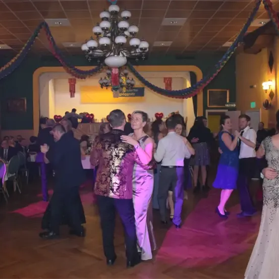 Ein Ballsaal-Tanzparty mit Paaren, die tanzen. Eine Kronleuchter hängt von der Decke.