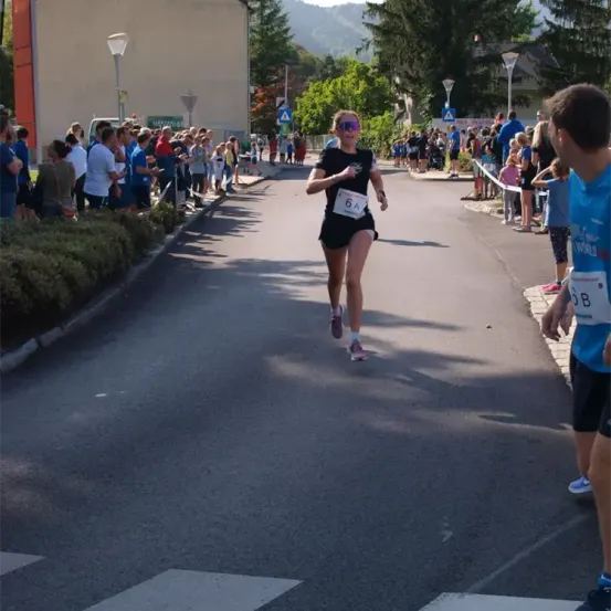 Eine Läuferin mit der Nummer 6A läuft einen Marathon. Viele Zuschauer beobachten sie.