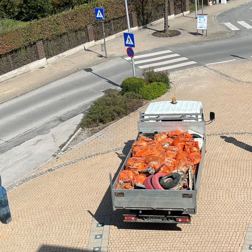 A top view of a truck with a full load of orange bags and tires at a pedestrian crossing.