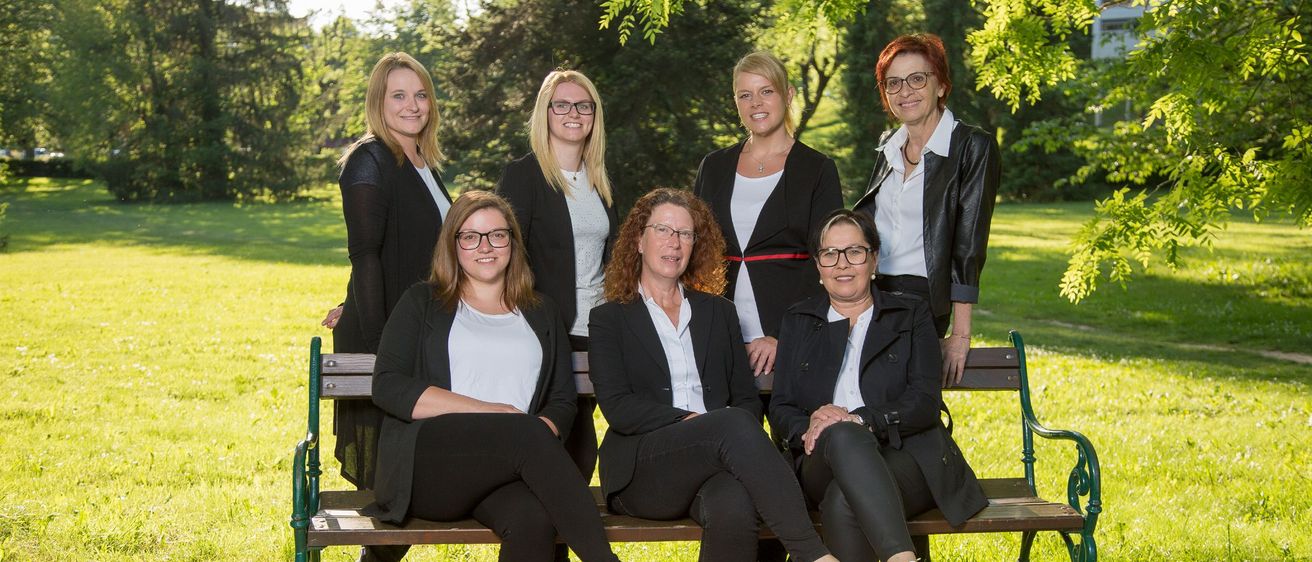 Bild enthält, Groupshot, Person, Sitting, Adult, Female, Woman, Grass, Glasses, Bench, Suit