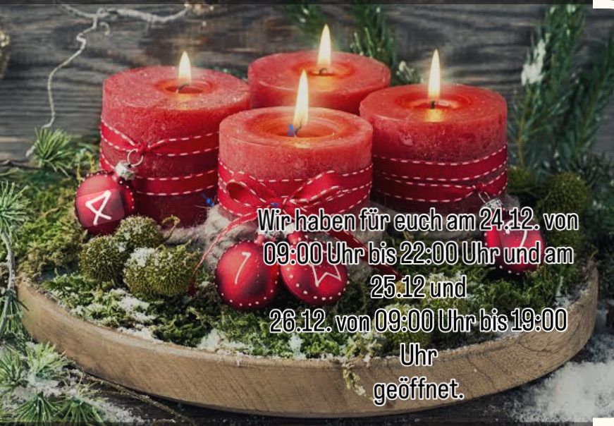 Vier rote Kerzen auf einem Holztablett, umgeben von Moos und Weihnachtskugeln. Der Text lautet: 'Wir haben für euch am 24.12. von 09:00 Uhr bis 22:00 Uhr und am 25.12 und 26.12. von 09:00 Uhr bis 19:00 Uhr geöffnet.'