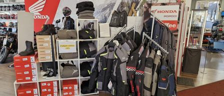 Ein Honda-Motorradgeschäft zeigt Jacken, Helme und Stiefel in Regalen und an Kleiderbügeln, mit einem Schild für 30% Rabatt für den Verkauf im neuen Jahr.