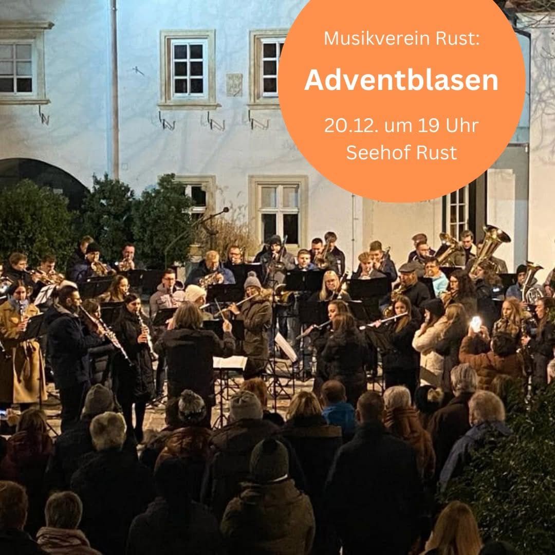 Ein Musikensemble spielt vor einem historischen Gebäude, während ein Publikum zuhört. Das Ensemble umfasst verschiedene Instrumente, und einige Musiker machen Fotos. Der Textüberlagerung lautet 'Musikverein Rust: Adventblasen 20.12. um 19 Uhr Seehof Rust.'
