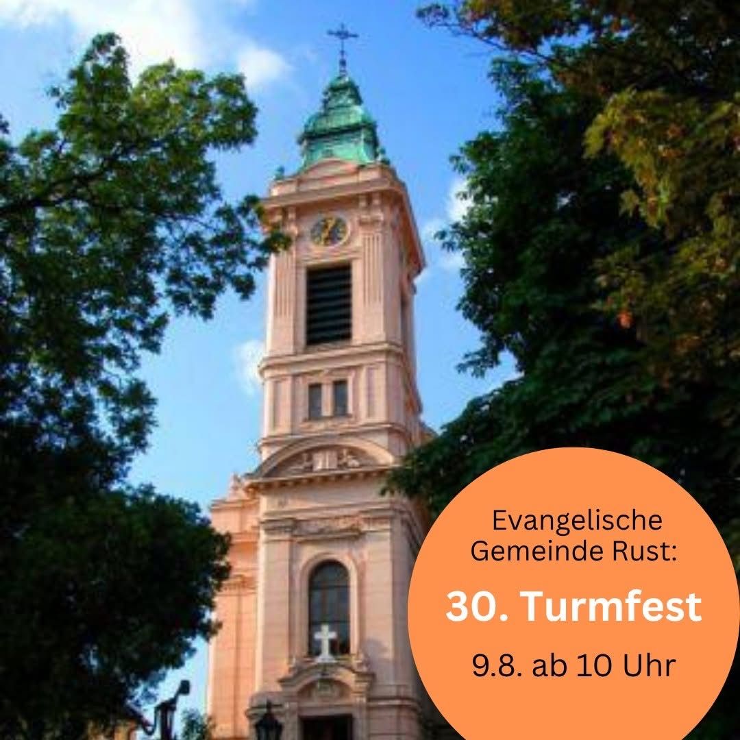 Ein Kirchturm mit einer Uhr und einem Kreuz auf der Spitze, umgeben von Bäumen. Der Text lautet 'Evangelische Gemeinde Rust: 30. Turmfest 9.8. ab 10 Uhr'.