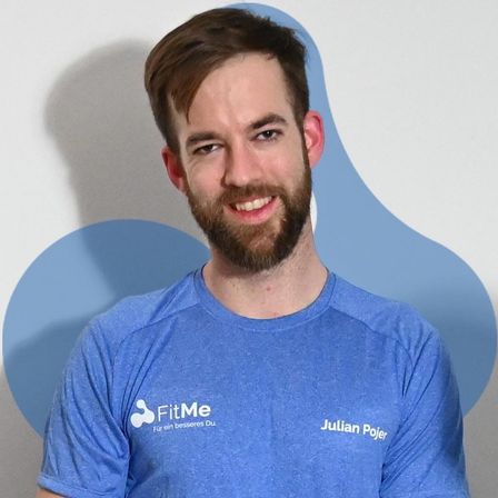 A man wearing a blue t-shirt with the text FitMe for a better you. The text Julian Pojer is on the right side of the shirt. The man has a beard and is standing in front of a blue background. He is smiling. He is probably posing for a photo.