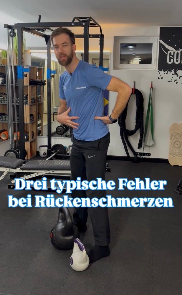 Ein Mann in einem blauen Shirt steht in einem Fitnessstudio mit den Händen auf dem Bauch und spricht über drei typische Fehler bei Rückenschmerzen.