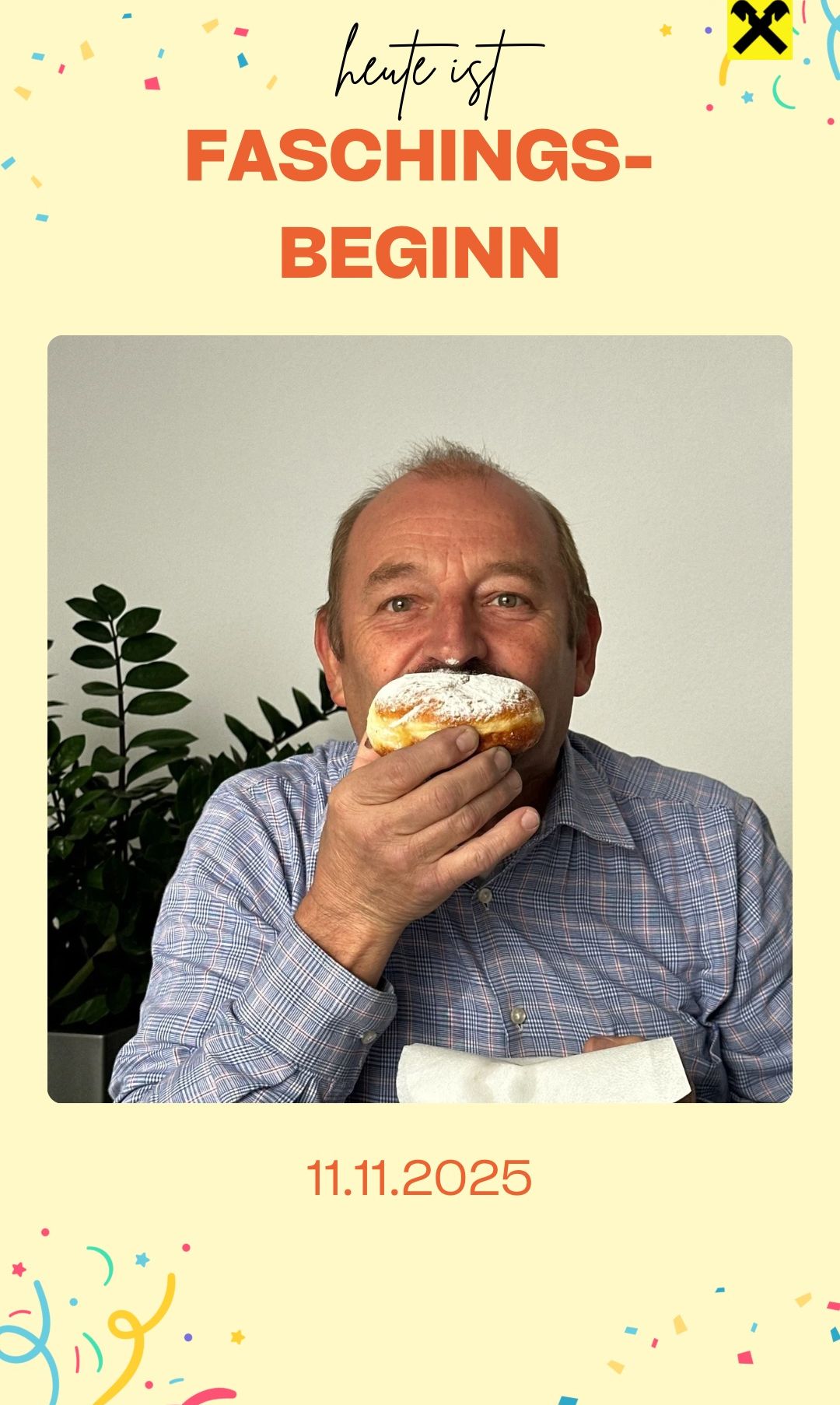 An older man in a blue shirt is eating a pastry with powdered sugar on it, holding it with one hand. A plant is behind him.