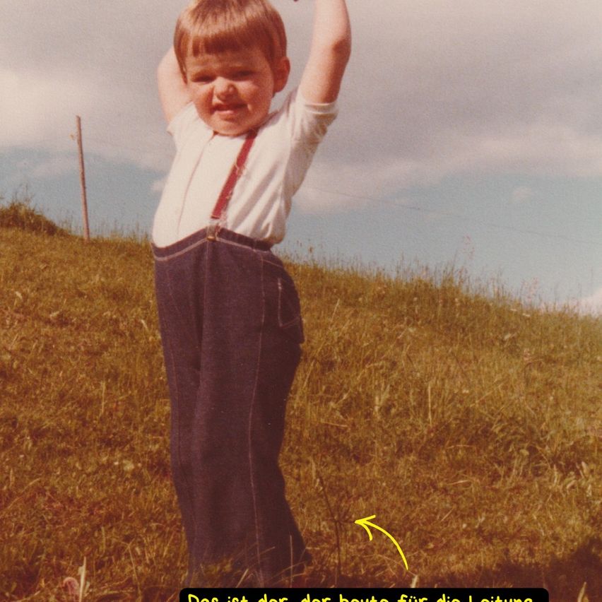 Ein kleiner Junge steht auf einem Grashügel und streckt seine Arme nach oben. Er trägt ein weißes Hemd, rote Hosenträger und dunkle Hosen. Ein gelber Pfeil zeigt auf seine Hose.