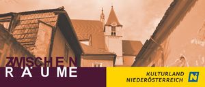 Eine Stadt mit Häusern und einem Kirchturm. Der Text 'SCHEN UM E' ist unten links angezeigt. Die Wörter 'KULTURLA NIEDEROSTERRE' sind unten rechts angezeigt.