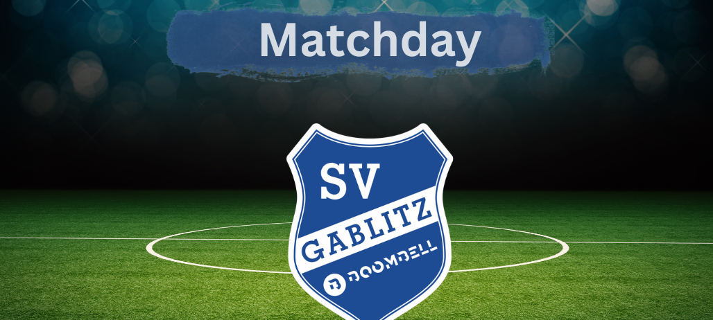 Ein Fußballfeld mit einem blau-weißen Logo, das 'SV GABLITZ' und 'ROOMBELL' in der Mitte zeigt.