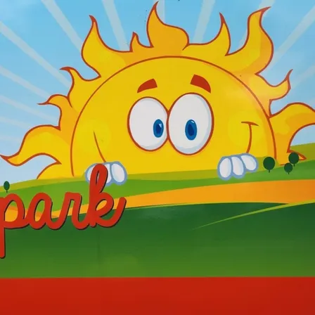 Ein Bild einer Sonne mit Strahlen und einem lächelnden Gesicht über einem grünen Hügel mit den Worten Freizeitpark Subenberg in roter und weißer Schrift geschrieben.