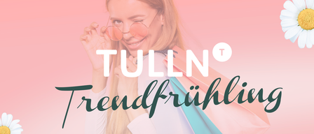 Eine lächelnde Frau mit Brille hält Einkaufstüten. Der Text lautet 'Trendfrühling' mit einem Herzsymbol und 'Dienstag März' auf einem rosa Hintergrund.