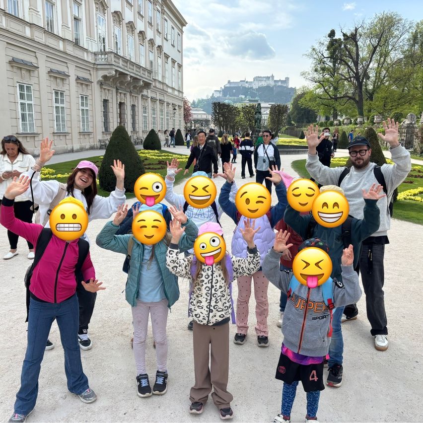 Gruppe von Menschen mit Emoji-Gesichtsmasken posiert für ein Foto vor einem Gebäude.